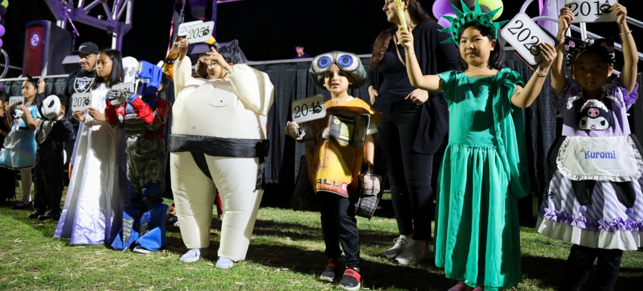 Children dressed up in various costumes in front of the stage